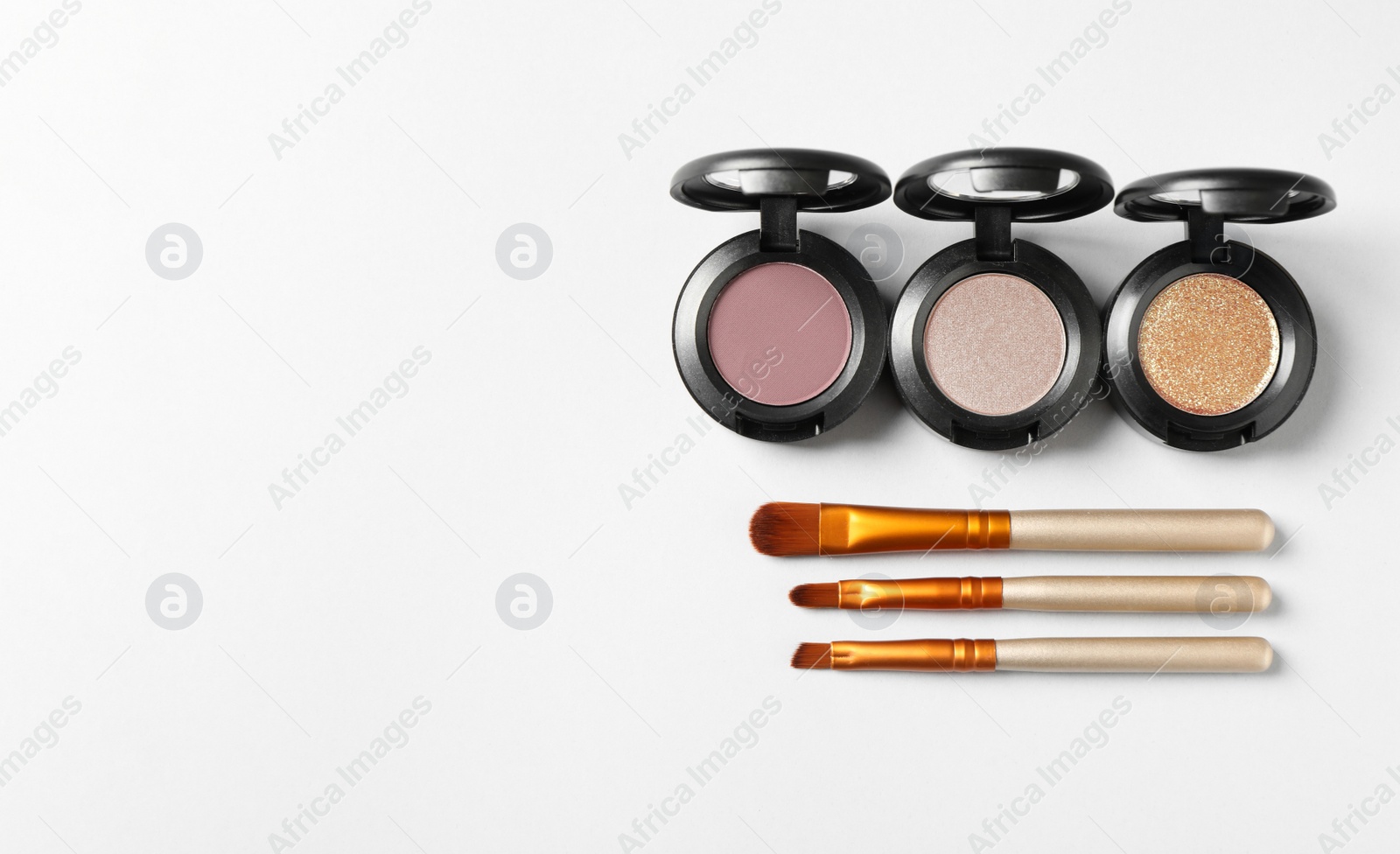 Photo of Different eye shadows and brushes on white background, flat lay. Space for text