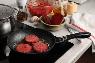 Cooking vegan cutlets in frying pan on stove