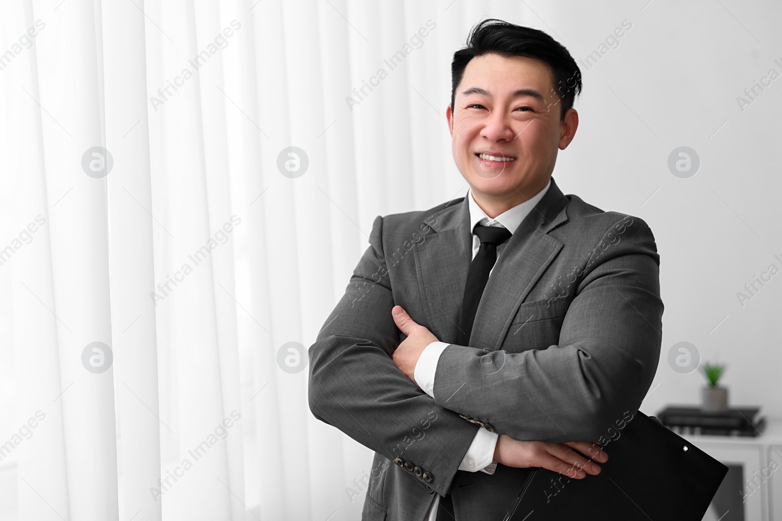 Photo of Portrait of happy notary with clipboard indoors, space for text