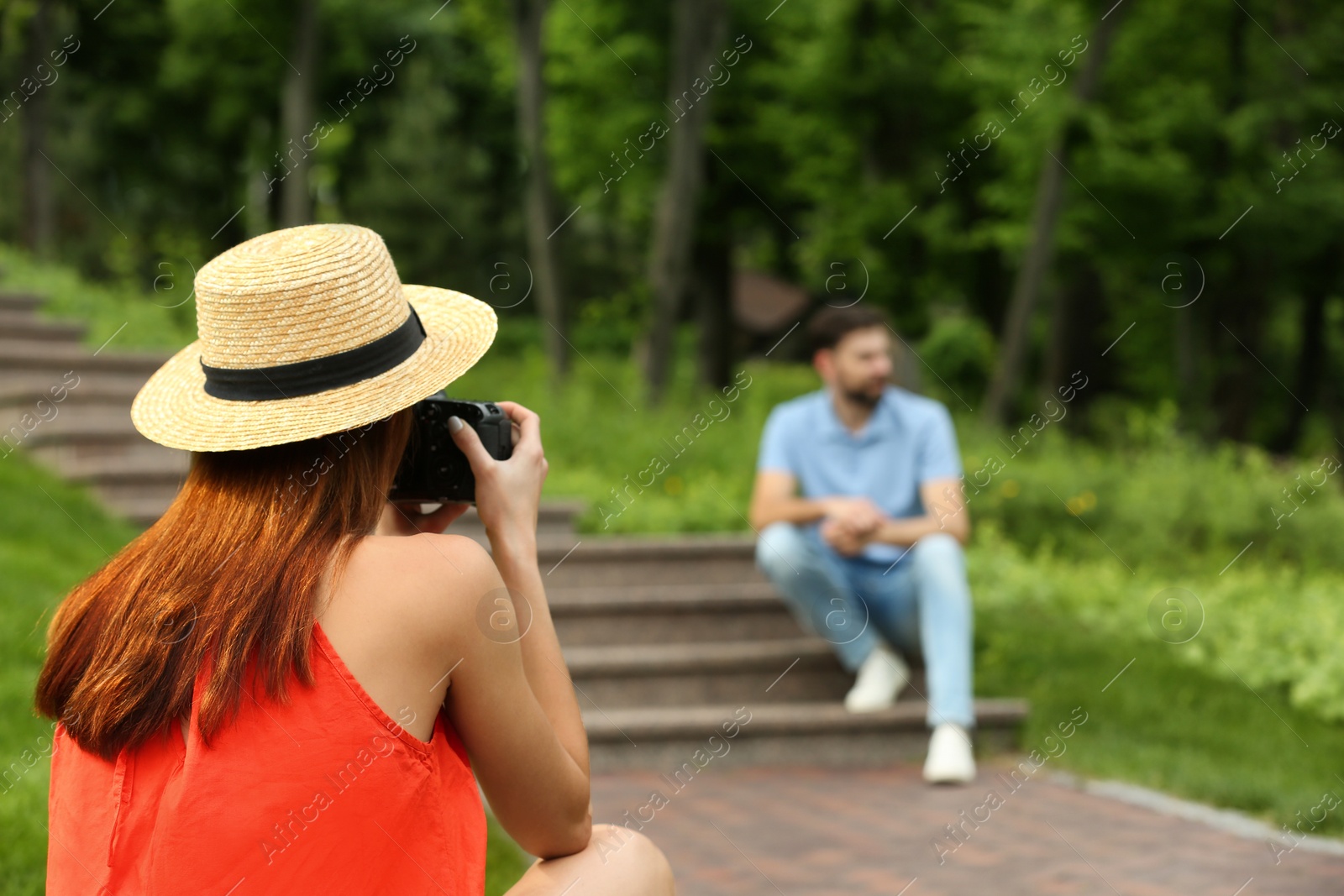 Photo of Photographer taking photo of man with professional camera in park