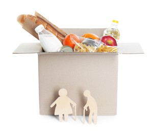 Humanitarian aid for elderly people. Cardboard box with donation food and wooden figures of couple isolated on white