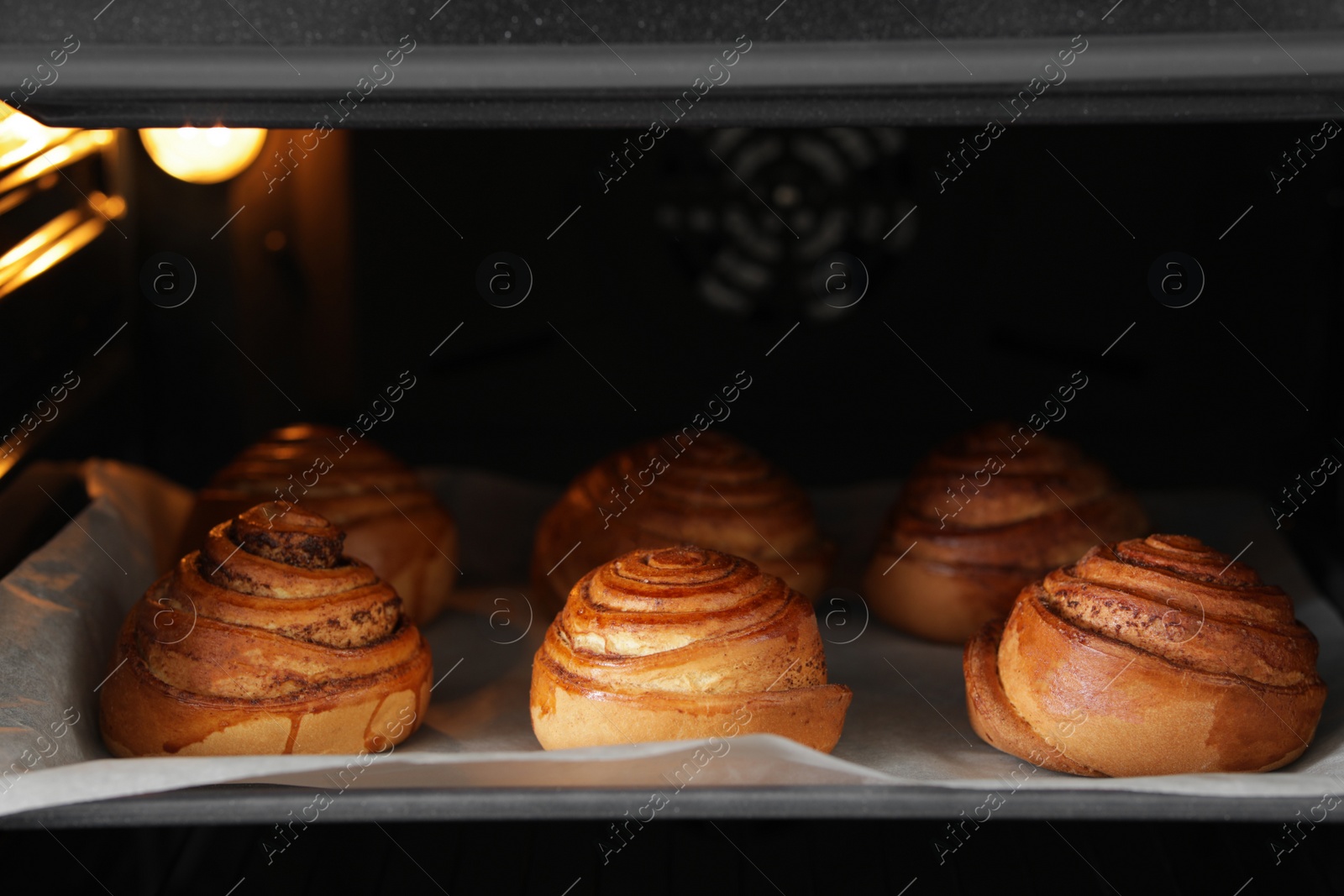 Photo of Tray with freshly baked buns in oven, closeup