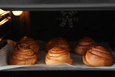 Tray with freshly baked buns in oven, closeup