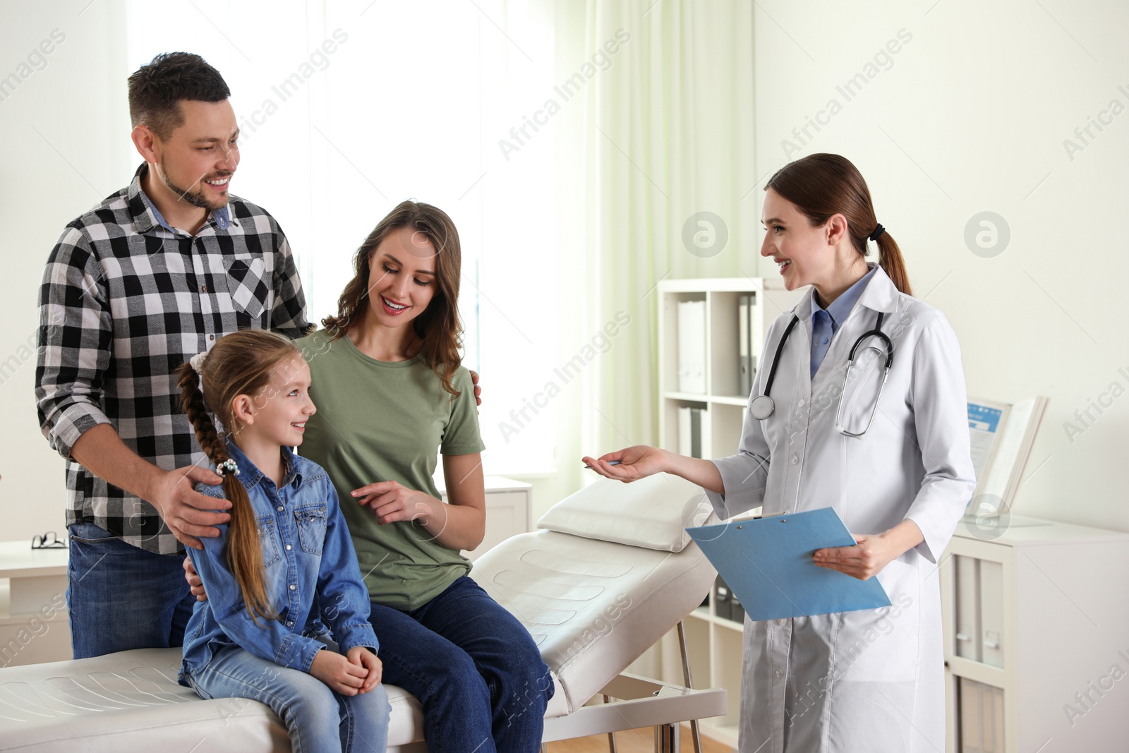 Photo of Parents and daughter visiting pediatrician. Doctor working with patient in hospital