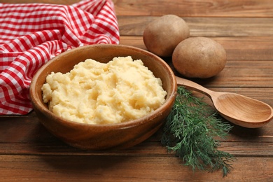 Photo of Bowl with tasty mashed potatoes on wooden table