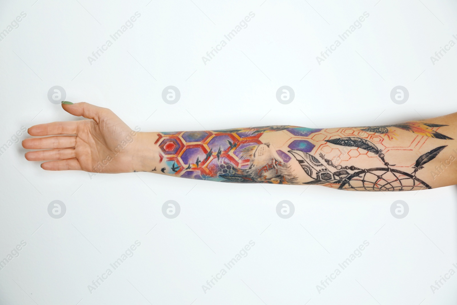 Photo of Woman with colorful tattoos on arm against white background, closeup