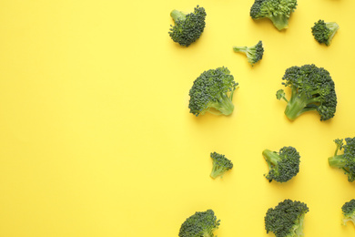 Photo of Fresh tasty broccoli on yellow background, flat lay. Space for text