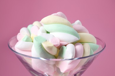Beautiful martini glass with colorful marshmallows on pink background, closeup