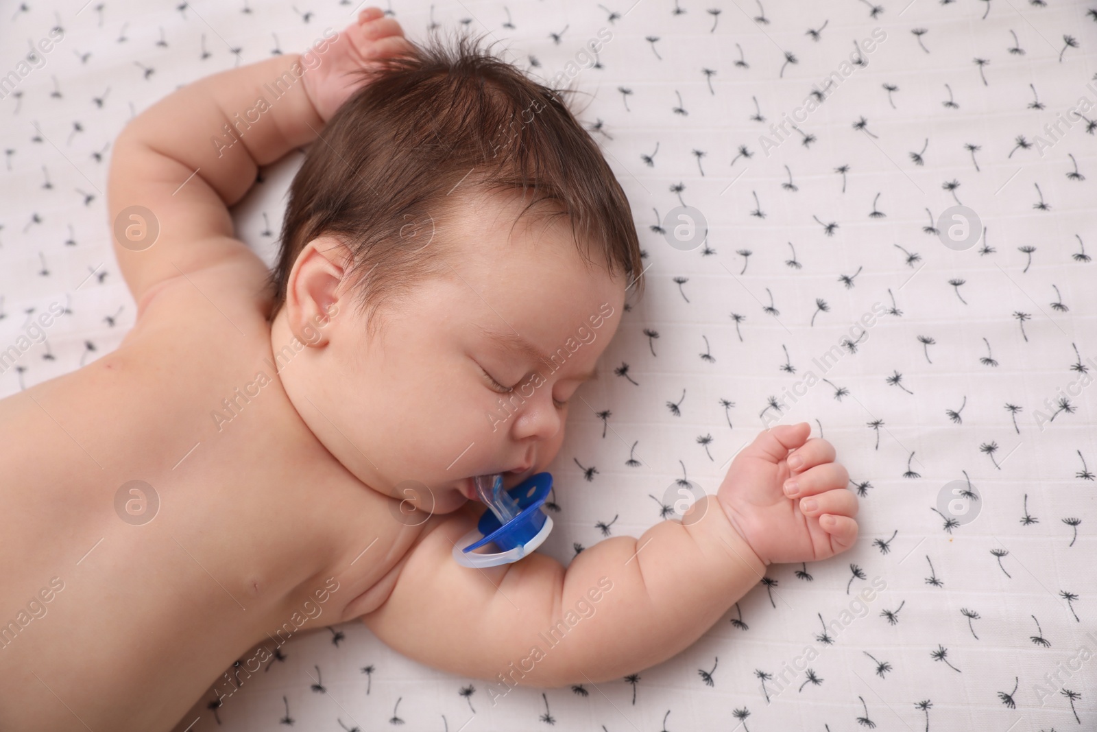 Photo of Cute little baby with pacifier sleeping on blanket, top view