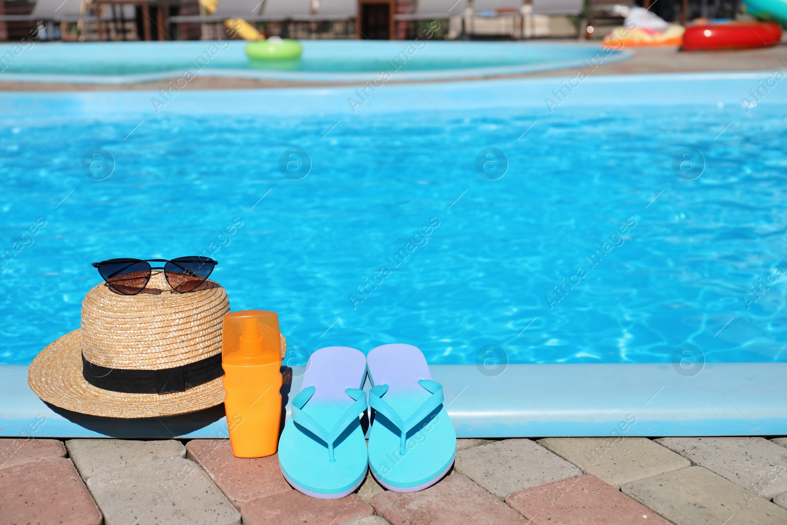 Photo of Beach accessories near swimming pool on sunny day. Space for text