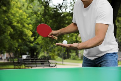 Man playing ping pong in park, closeup