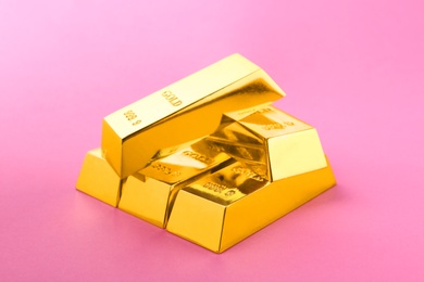 Photo of Precious shiny gold bars on color background