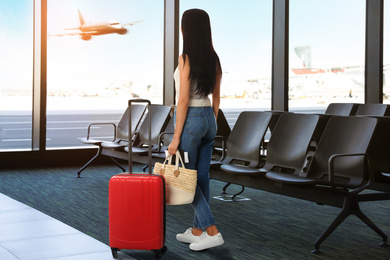 Image of Woman with bag and travel suitcase at airport terminal. Summer vacation