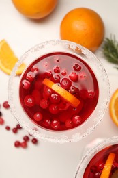 Photo of Tasty cranberry cocktail in glass on white table, flat lay