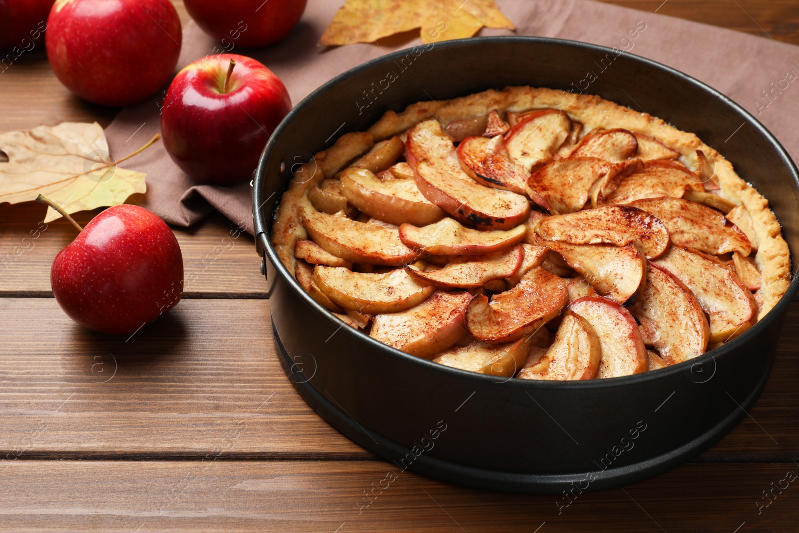 Photo of Delicious apple pie and fresh fruits on wooden table