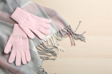 Stylish gloves and scarf on white wooden background, above view. Space for text