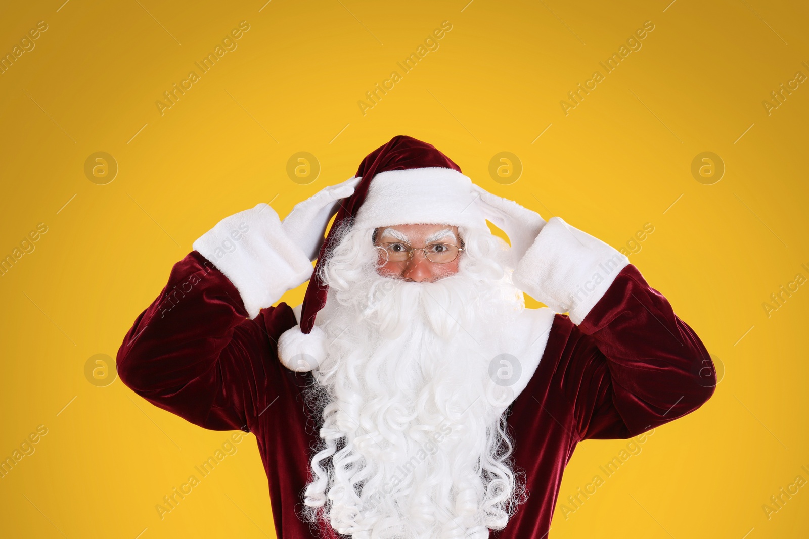Photo of Portrait of emotional Santa Claus on yellow background