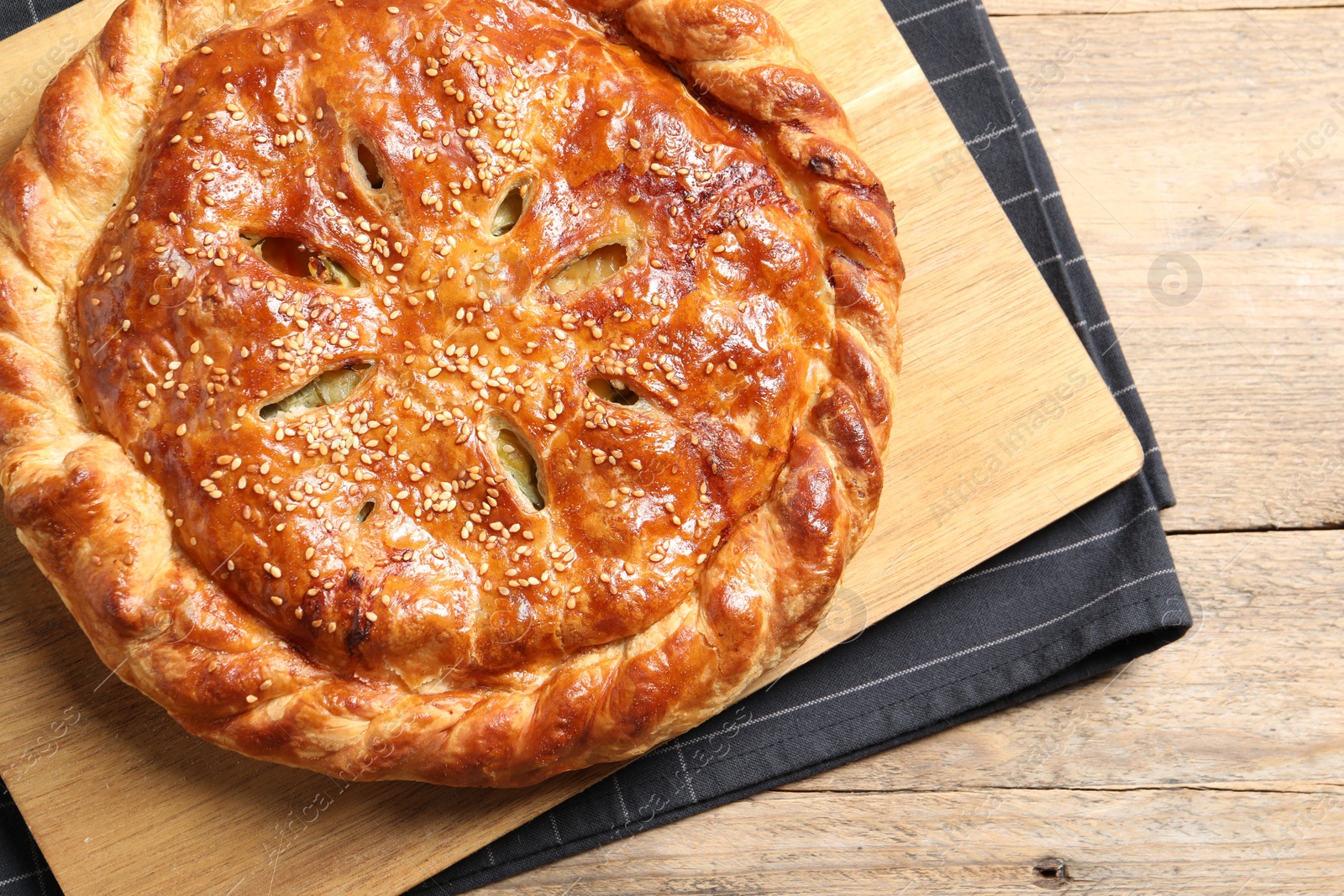 Photo of Tasty homemade pie with filling on wooden table, top view