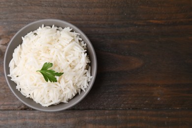 Photo of Bowl of delicious rice with parsley on table, top view. Space for text