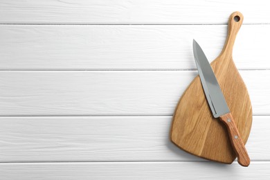 Photo of One sharp knife and board on white wooden table, top view. Space for text