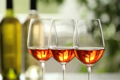 Photo of Glasses of white wine on blurred background, closeup