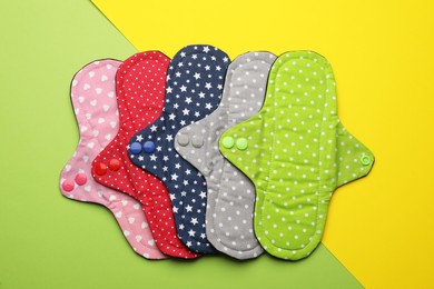 Many reusable cloth menstrual pads on color background, flat lay
