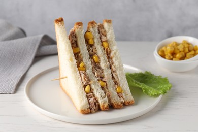 Photo of Delicious sandwich with tuna and corn on white wooden table, closeup