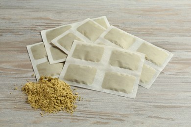 Photo of Mustard powder and plasters on wooden table