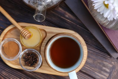 Tray with delicious tea and ingredients on wooden table, flat lay