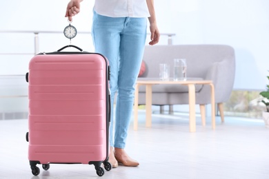 Woman weighing suitcase indoors. Space for text