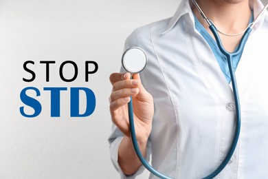 Image of STOP STD. Doctor with stethoscope on white background, closeup