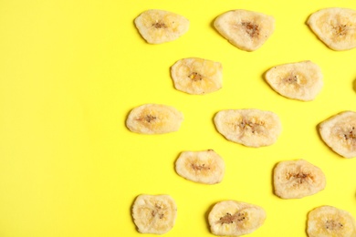 Flat lay composition with banana slices on color background, space for text. Dried fruit as healthy snack
