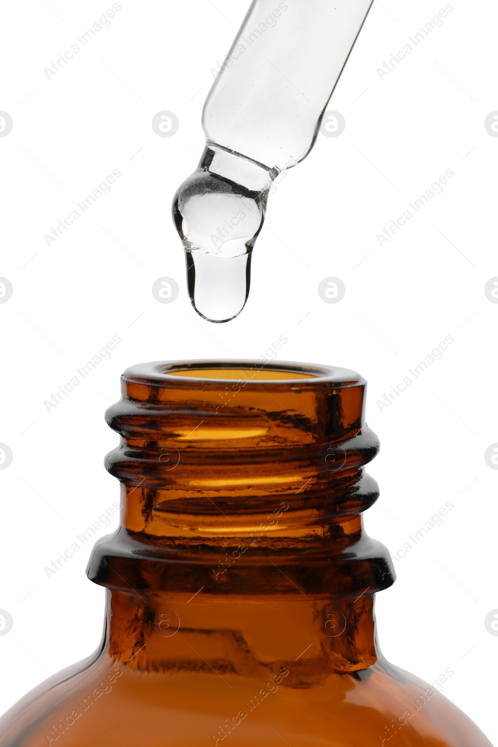 Photo of Dripping clear facial serum from pipette into glass bottle on white background, closeup