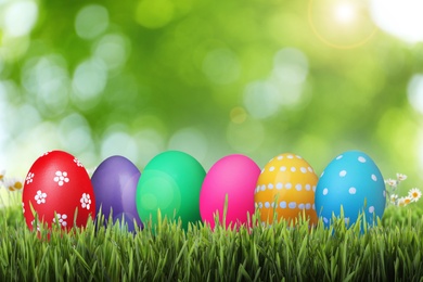 Image of Bright Easter eggs on green grass outdoors