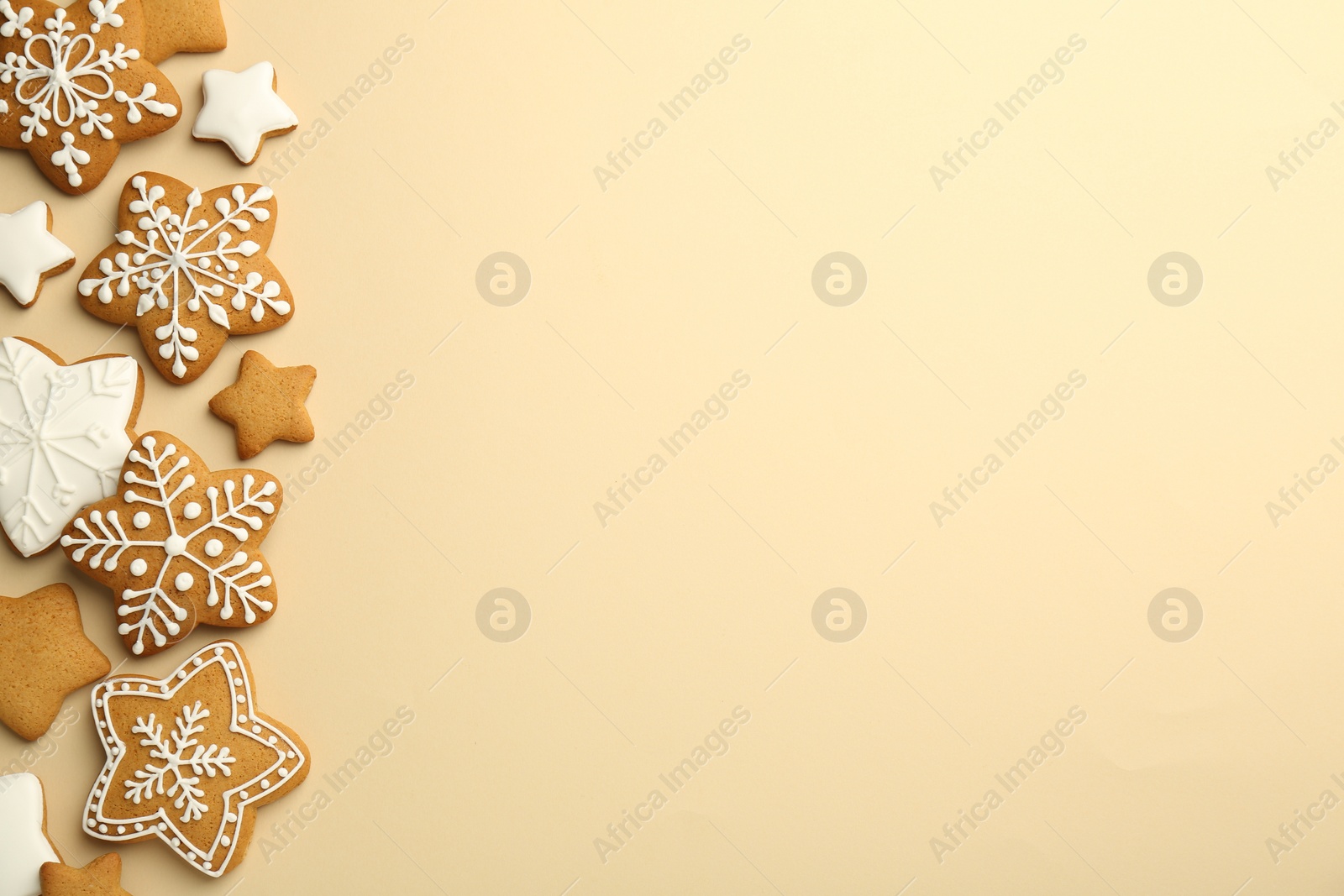 Photo of Tasty Christmas cookies with icing on beige background, flat lay. Space for text