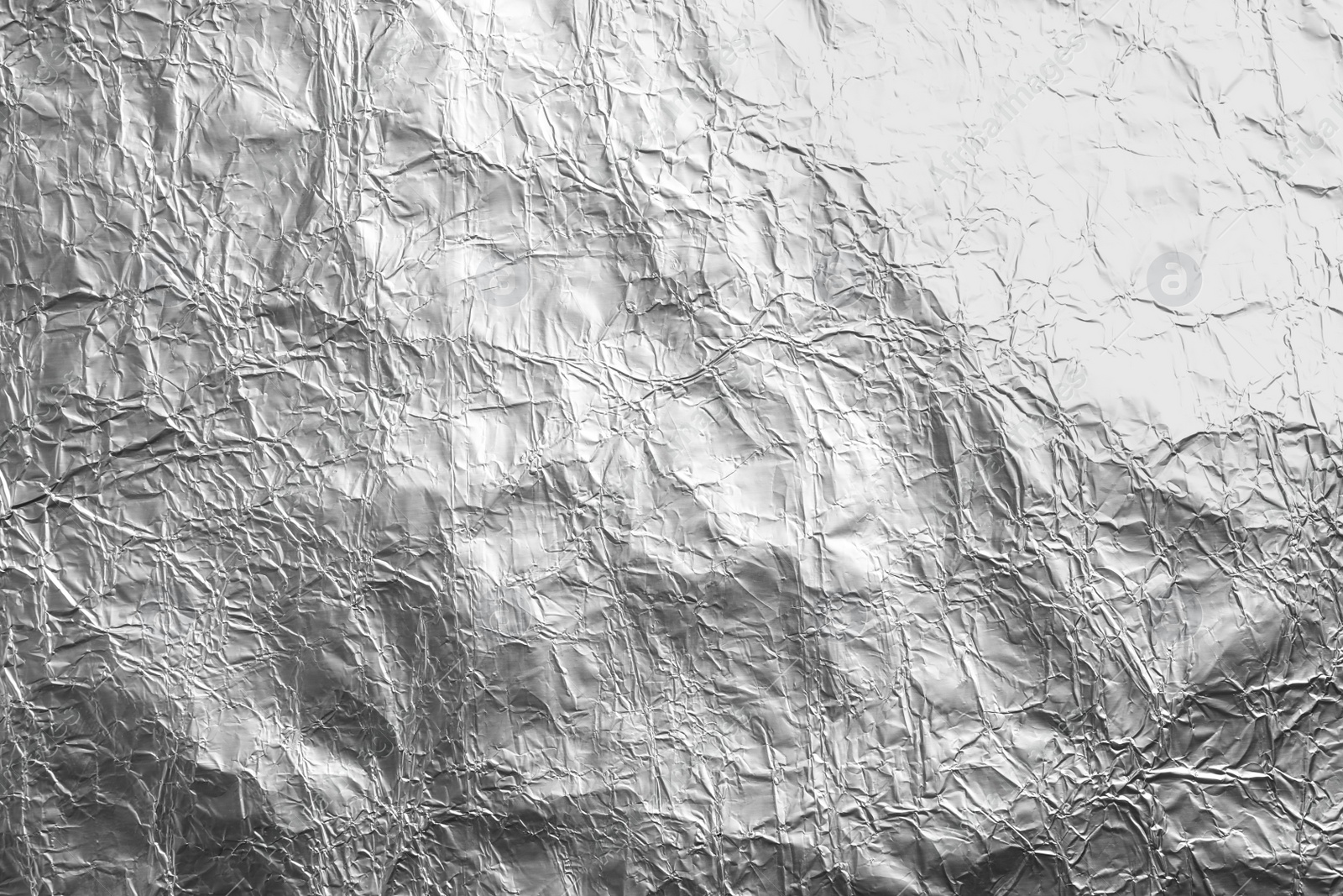 Photo of Crumpled silver foil as background, closeup view