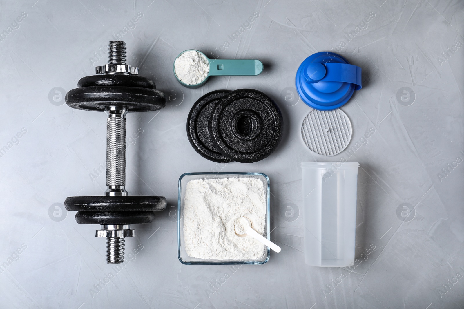 Photo of Flat lay composition with protein powder and dumbbell on grey background