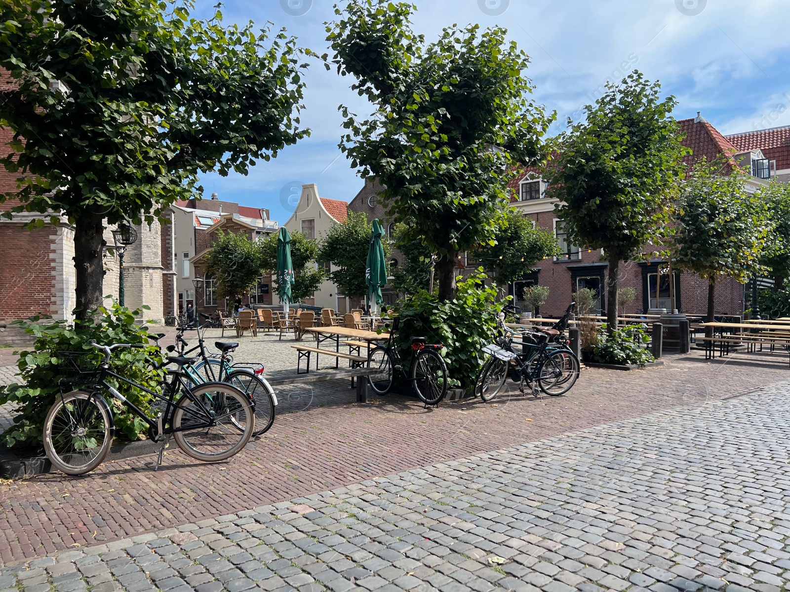 Photo of City street with beautiful buildings, plants and bicycles