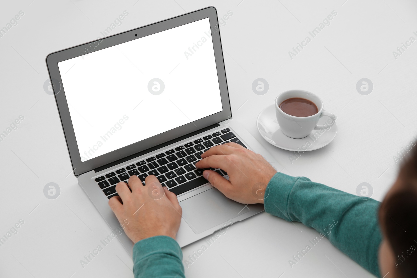 Photo of Young man working with modern laptop at table, closeup. Mockup for design