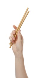 Photo of Woman holding eco friendly bamboo straws on white background, closeup. Conscious consumption