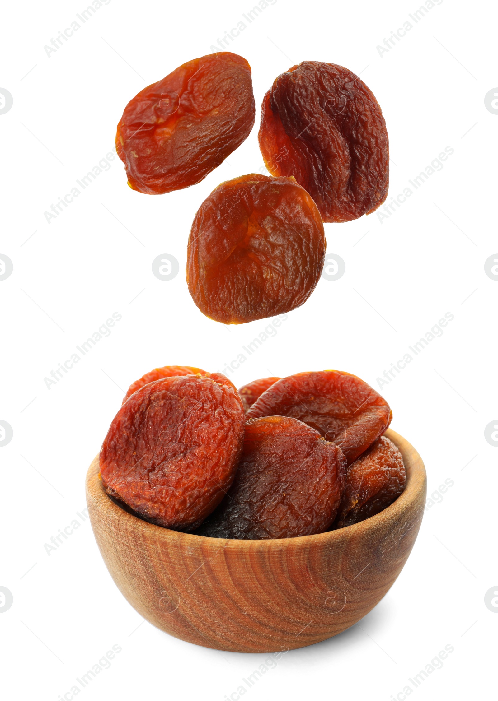 Image of Tasty dried apricots falling into bowl on white background