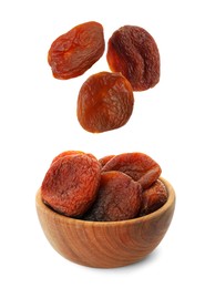 Tasty dried apricots falling into bowl on white background