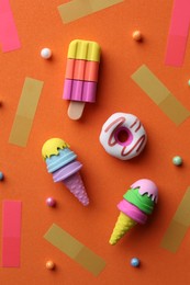 Photo of Flat lay composition with toy ice creams and donut on orange background