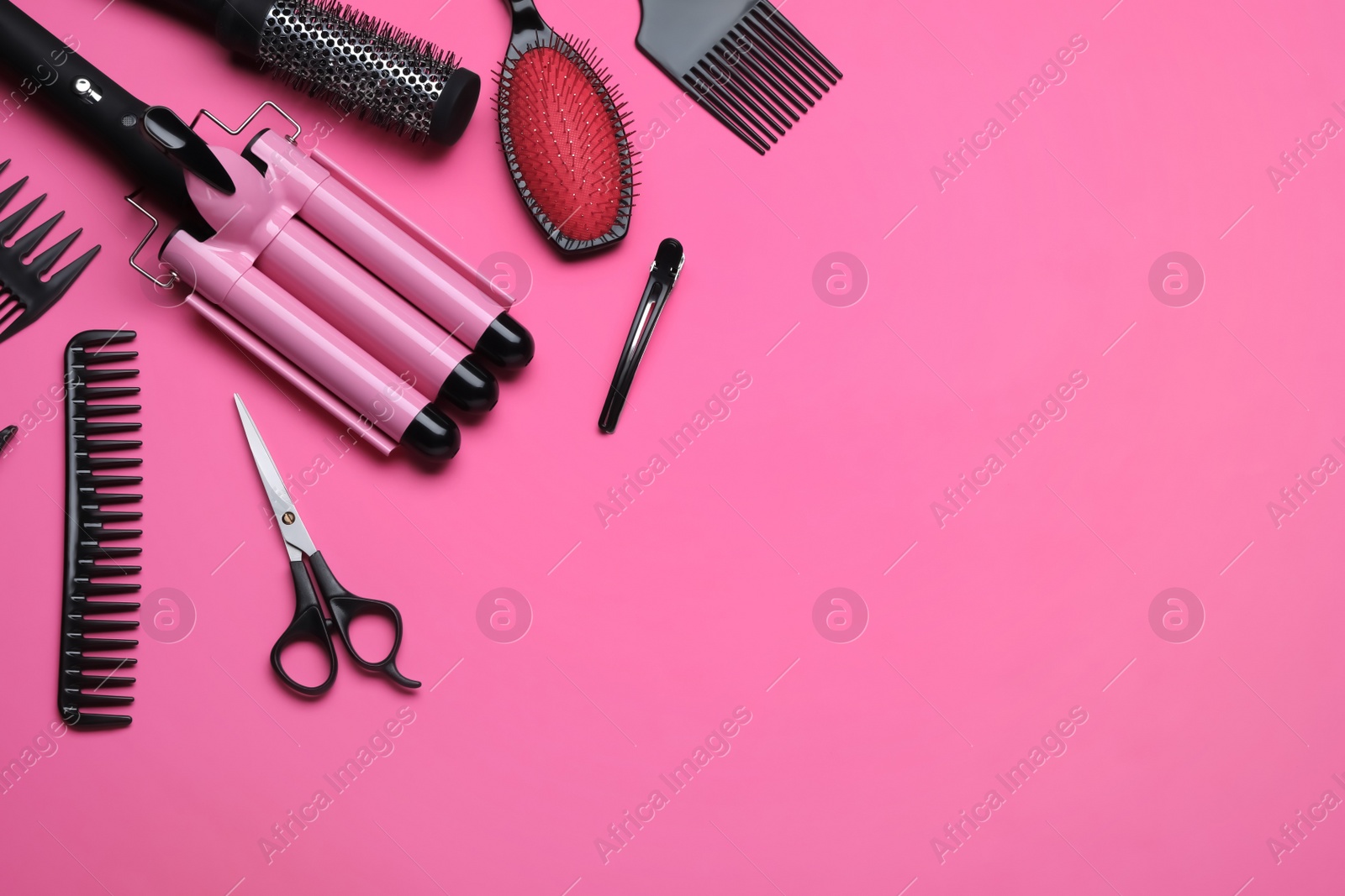 Photo of Flat lay composition of professional hairdresser tools on pink background, space for text