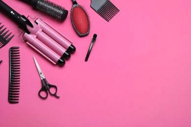 Photo of Flat lay composition of professional hairdresser tools on pink background, space for text