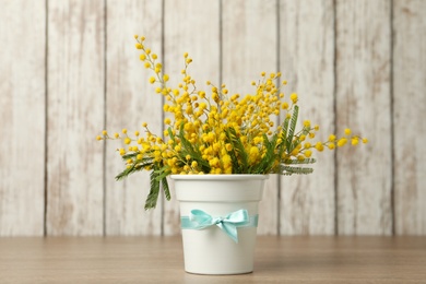 Photo of Bouquet of beautiful mimosa flowers on wooden table