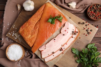 Photo of Flat lay composition with delicious smoked bacon on wooden table