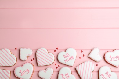 Photo of Valentine's day cookies on pink table, flat lay. Space for text