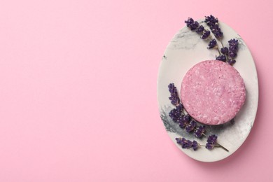 Photo of Solid shampoo bar and lavender flowers on pink background, top view. Space for text