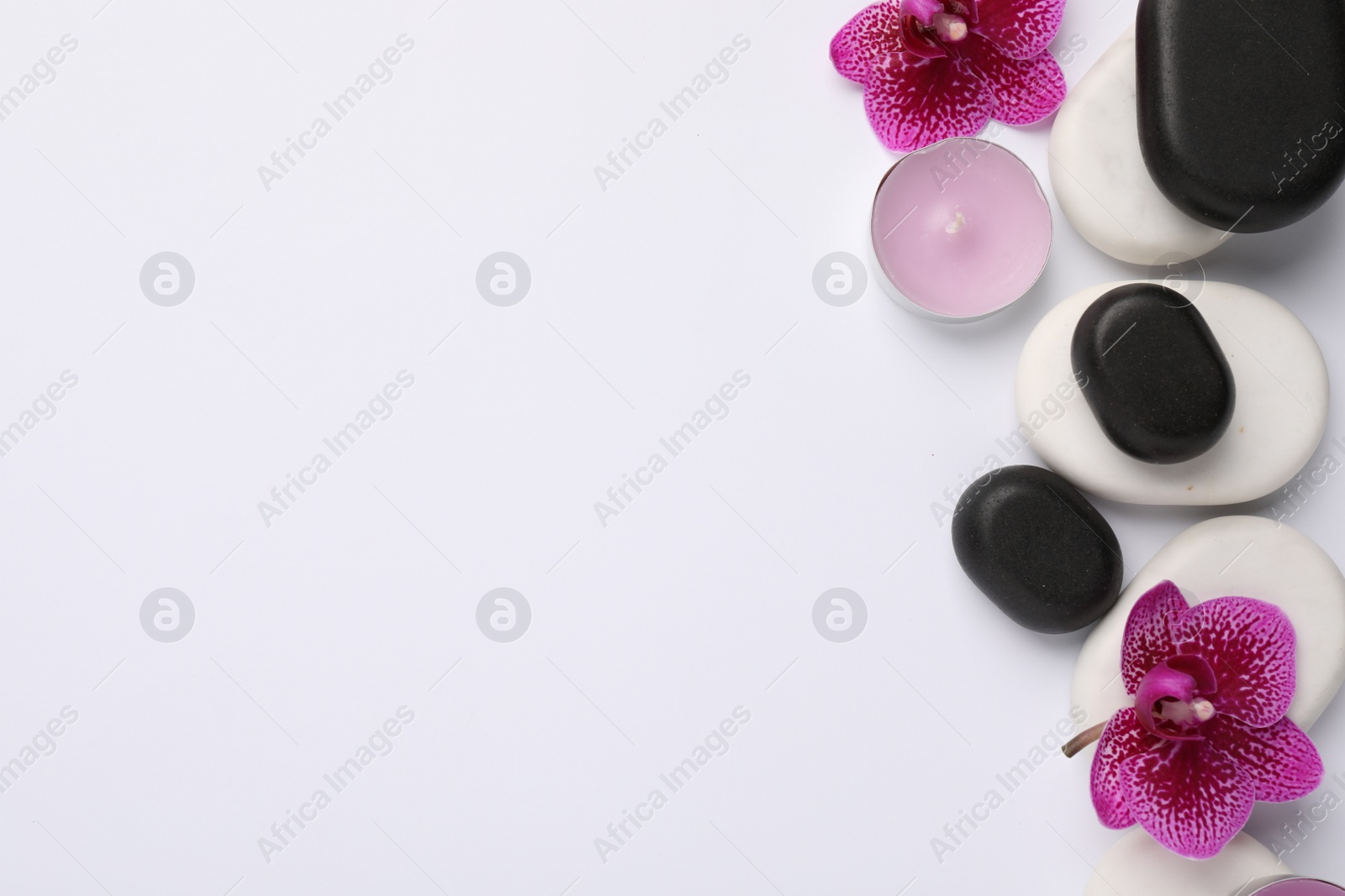 Photo of Flat lay composition with spa stones and flowers on white background, space for text